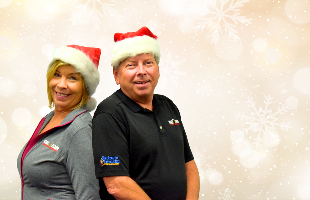 two people standing back to back with santa hats on