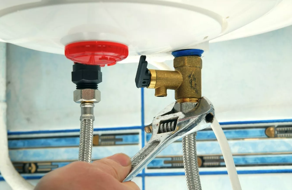 A plumber adjusting a water connection with a wrench