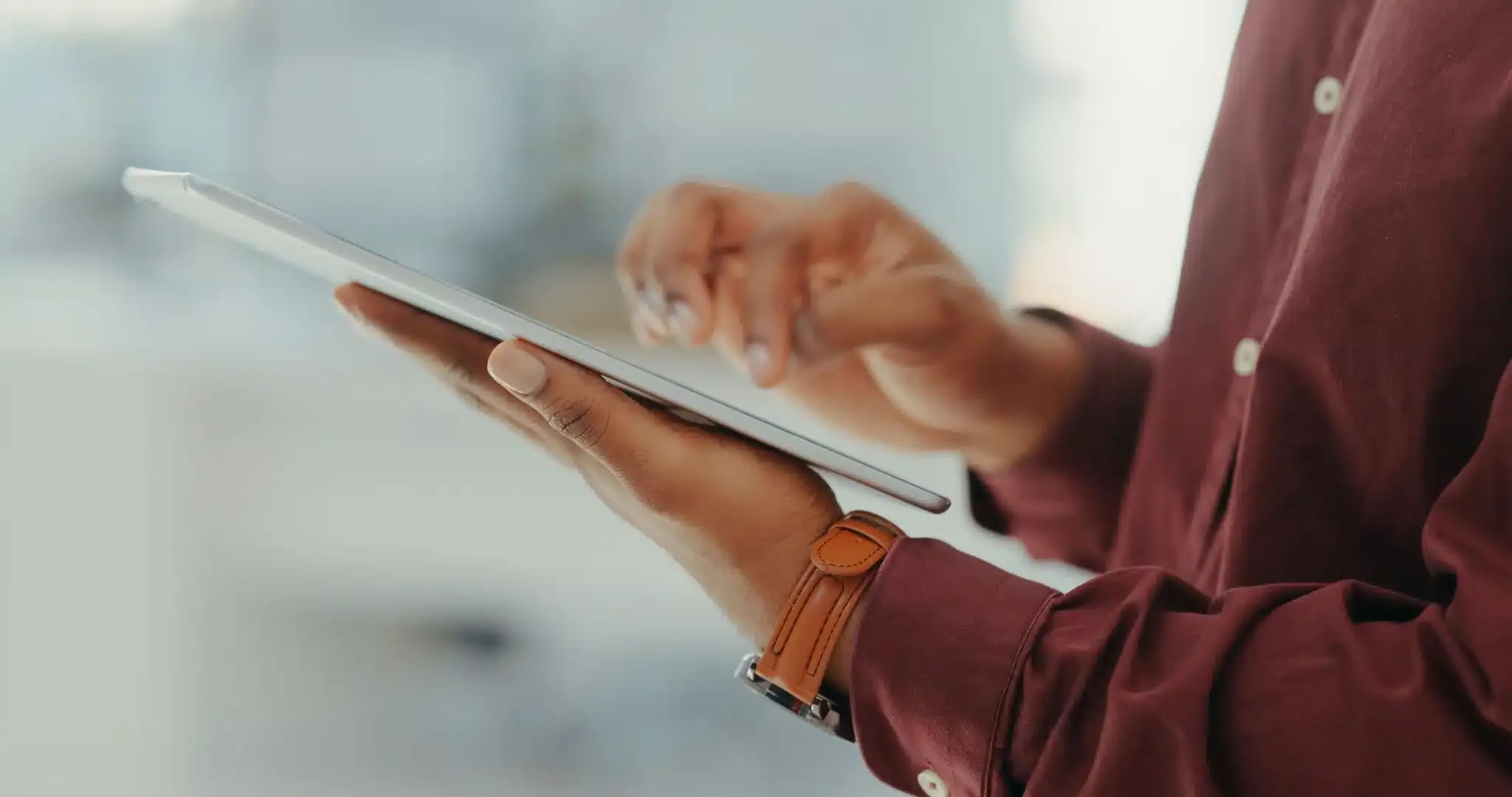 person holding tablet with hand raised above ready to type